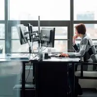 Salariée au bureau travaillant sur un double écran d'ordinateur