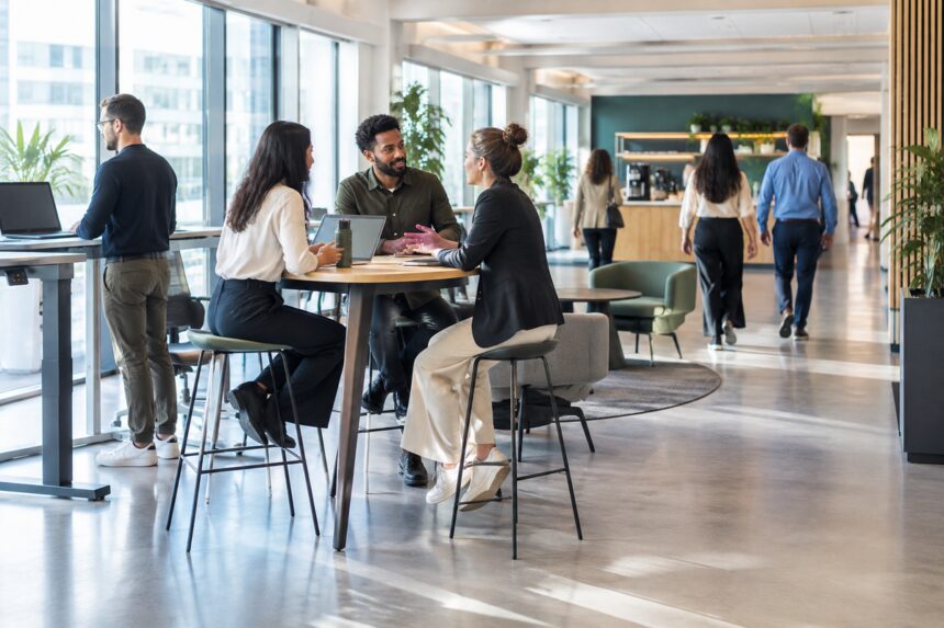 Salariés alternant travail assis, réunion debout et déplacements dans un bureau aménagé